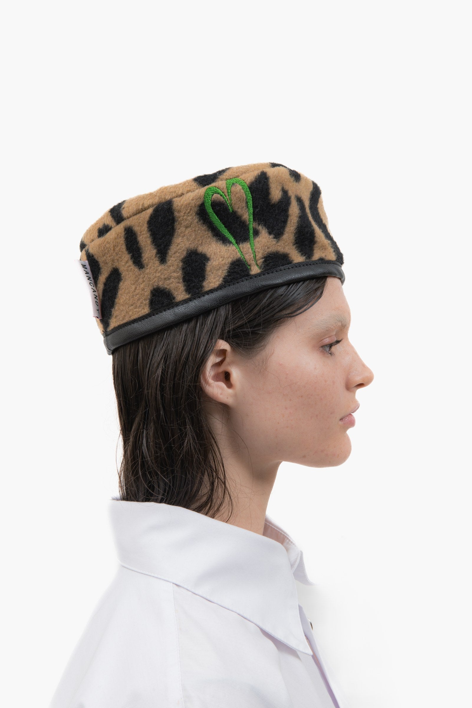 Side profile of the Officer Cap with embroidered heart detailing and bound edge.