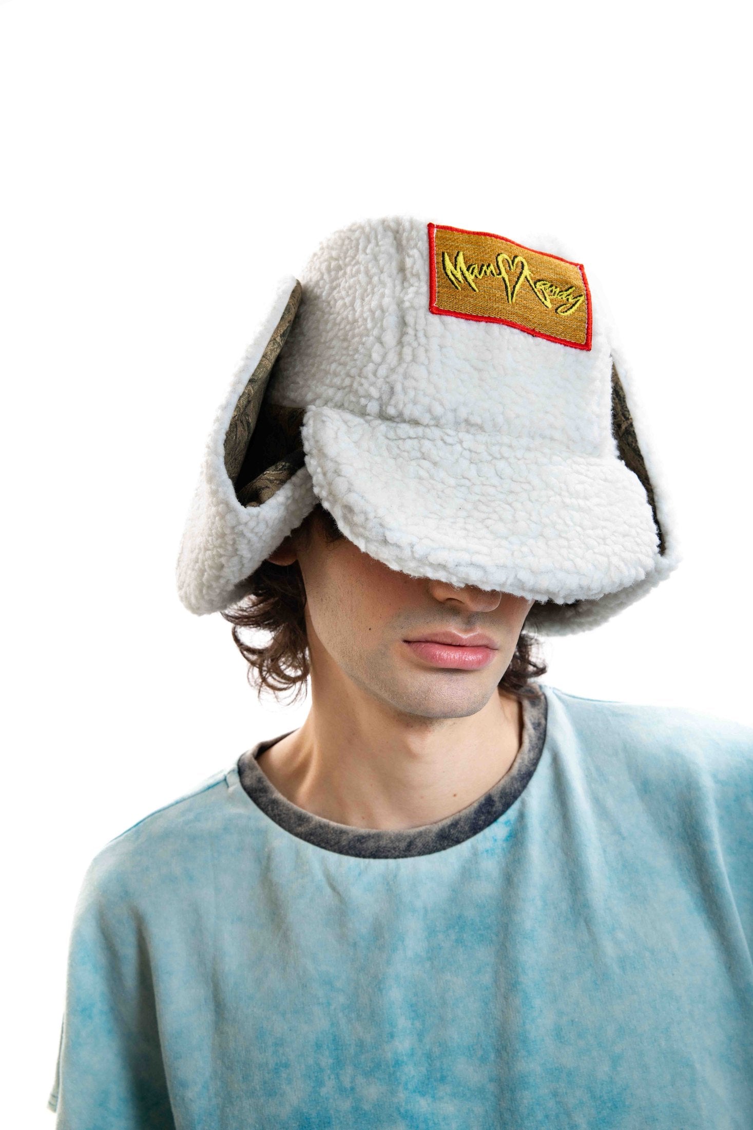 Close-up of the Off Duty Hat on a male model showing the embroidered MANCANDY patch