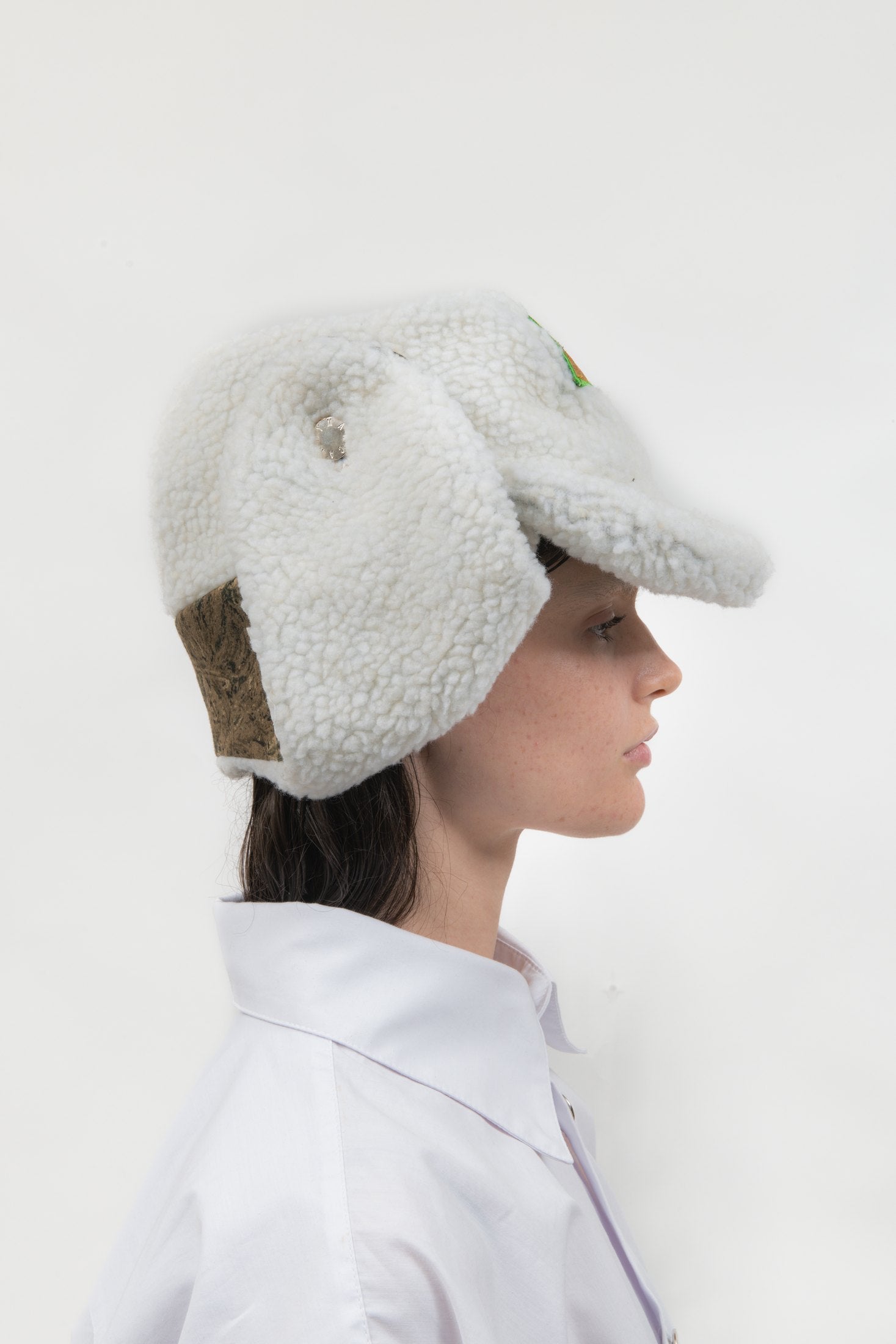 Side profile of the Off Duty Hat showing the faux shearling ear flap and Tree Camo fleece panel