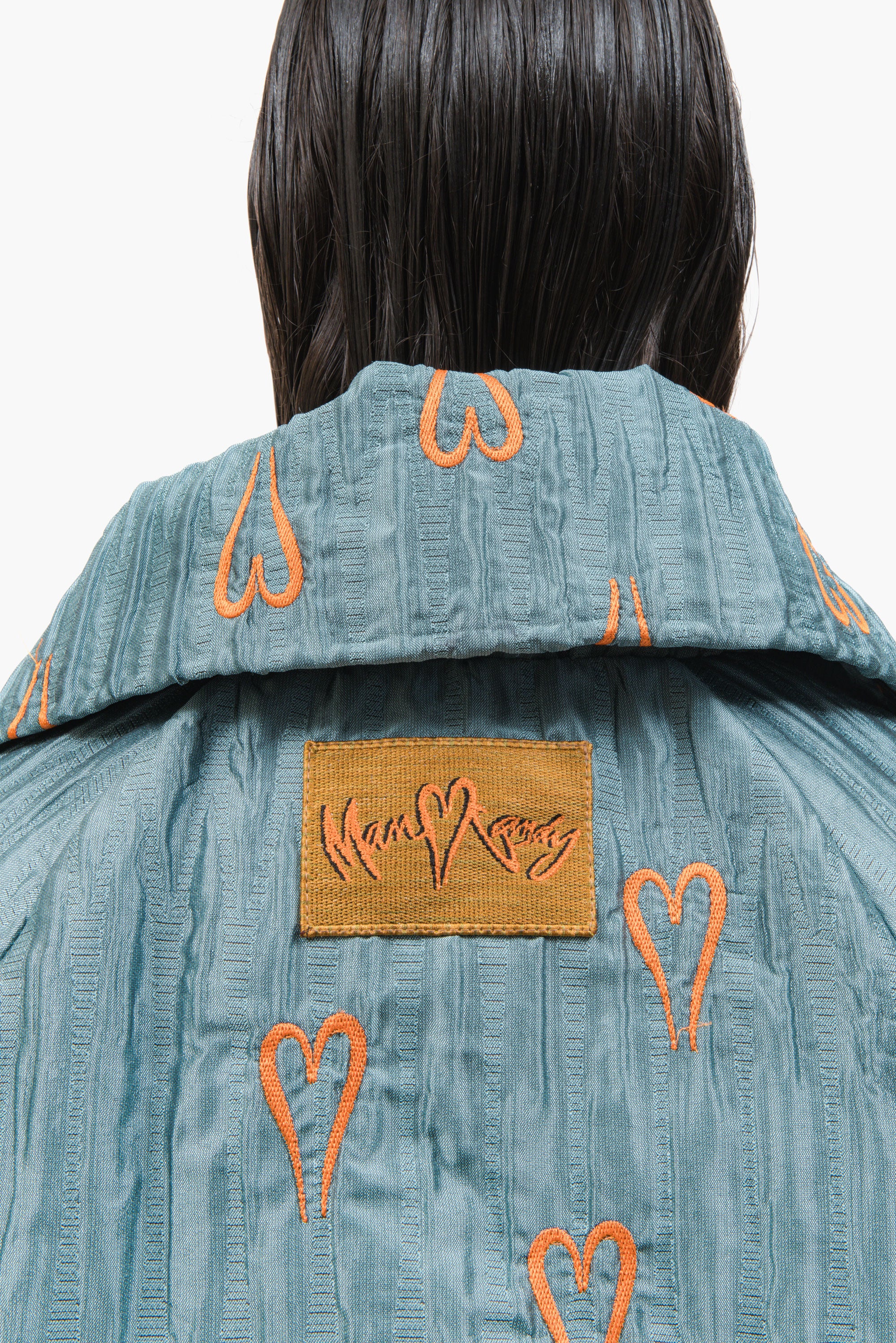 Hearts Bomber Jacket in textured blue steel fabric with all-over heart embroidery and oversized silhouette.