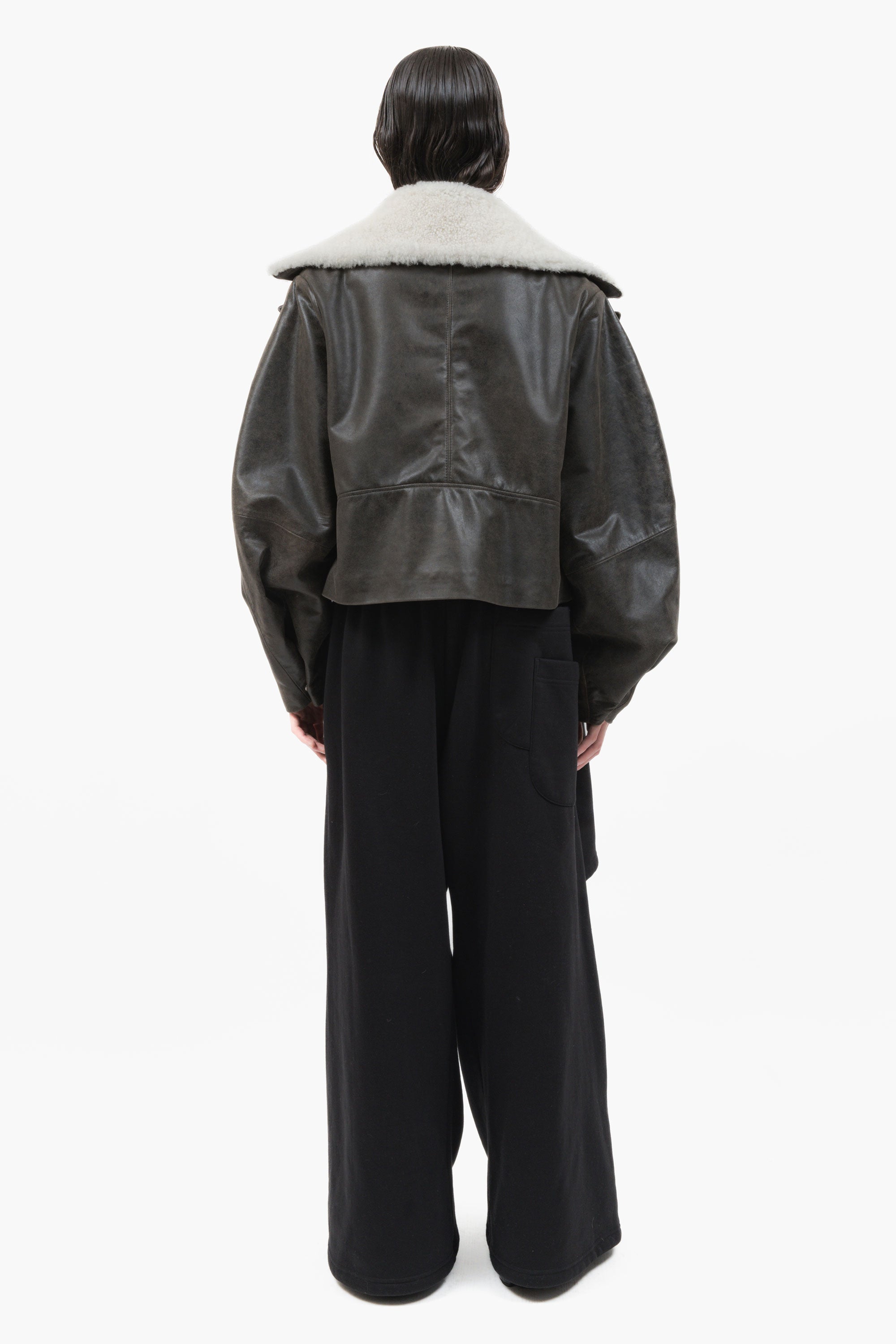 MANCANDY Wide Aviator Jacket in crackled black leather featuring a detachable shearling collar, oversized fit and curved sleeves.